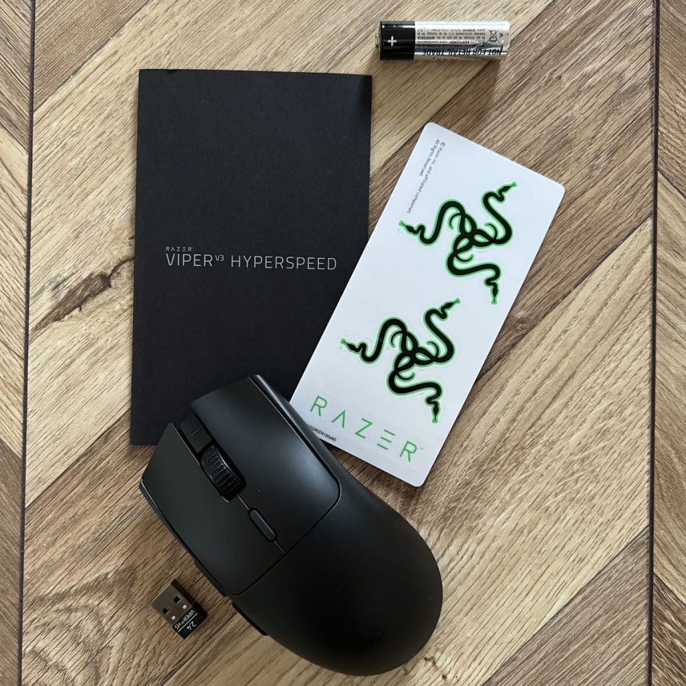 Foto:senses.se-Razer-v3-Hyperspeed-med-klistermärken-,ett-AAbatteri-,en-manual-och-en-Hyperspeed-Wireless-Dongle